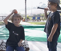 国外一个小男孩拿棒球棍打另一个把苹果放头上的小男孩，然后……